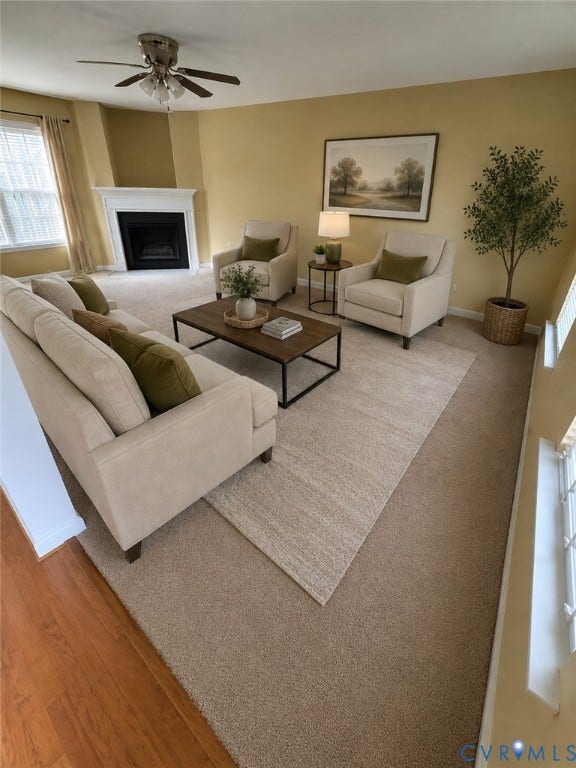 Carpeted open-concept  living room with gas fireplace. *Virtually enhanced