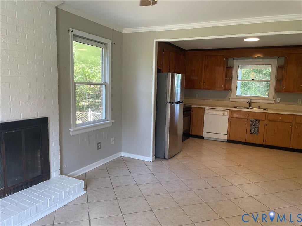 Kitchen with wood cabinetry, stainless steel refrigerator, and white dishwasher