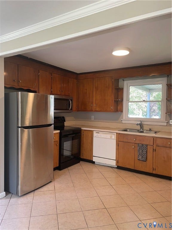 Tile flooring, wood cabinetry, stainless steel refrigerator, built-in microwave, and electric range
