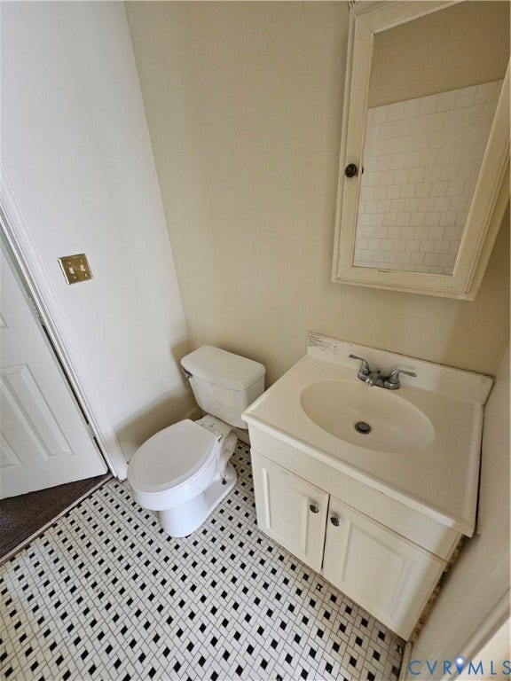 1711 Halifax Avenue, Richmond, VA 23224 White vanity with integrated sink, chrome faucet, and panel-style cabinet doors