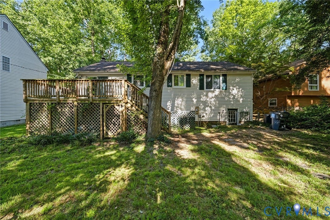 2709 Sutters Mill Court, Midlothian, VA 23112 Rear exterior with a wood-finish deck, lattice skirting, and a sloped grass lawn