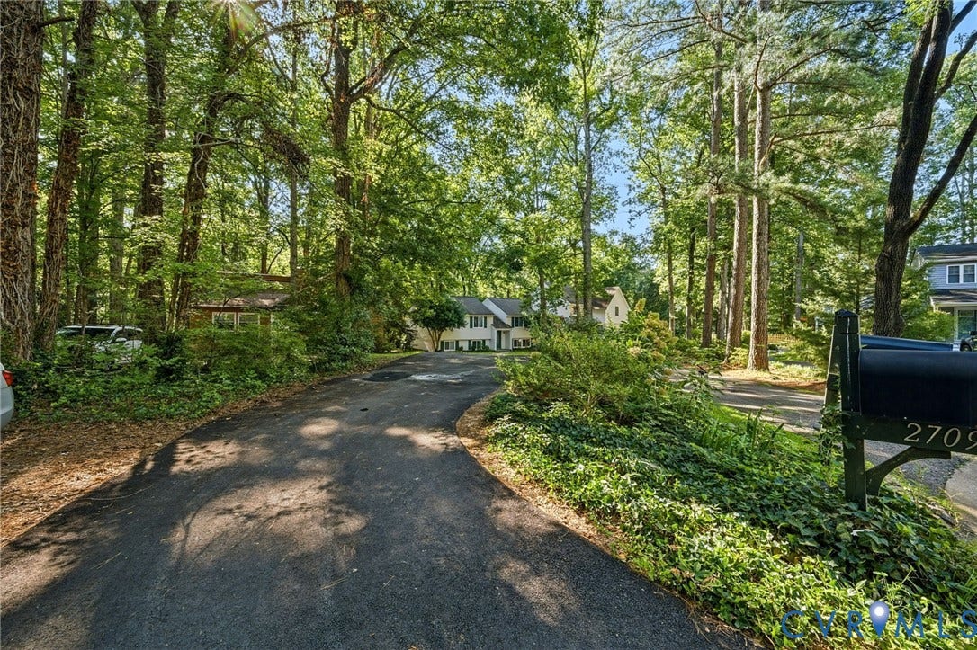 2709 Sutters Mill Court, Midlothian, VA 23112 Paved driveway bordered by dense foliage, mature trees, and a mailbox with house numbers