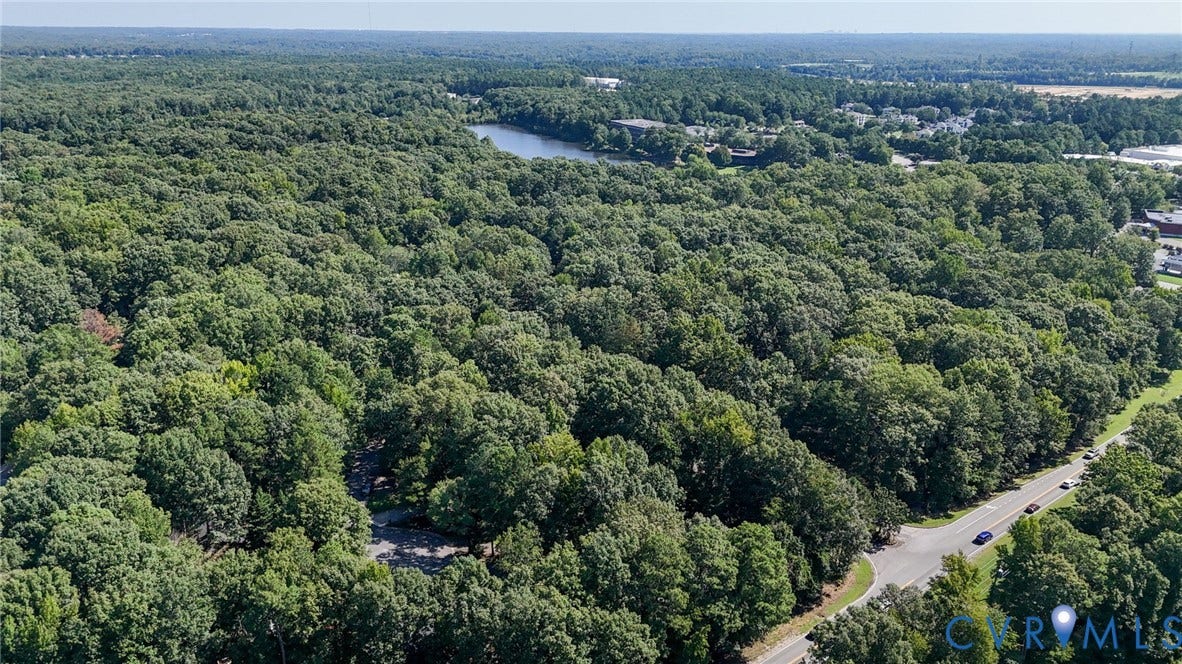 2709 Sutters Mill Court, Midlothian, VA 23112 Expansive wooded parcel featuring mature trees, a paved road border, and proximity to a body of water