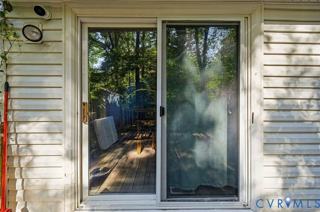 2709 Sutters Mill Court, Midlothian, VA 23112 White vinyl siding exterior with a sliding glass door and an exterior light fixture