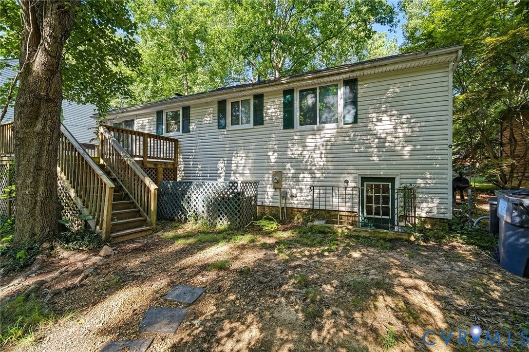 2709 Sutters Mill Court, Midlothian, VA 23112 Rear exterior featuring vinyl siding, multiple windows with shutters, a wooden deck with railing and stairs, and a ground-level exterior door