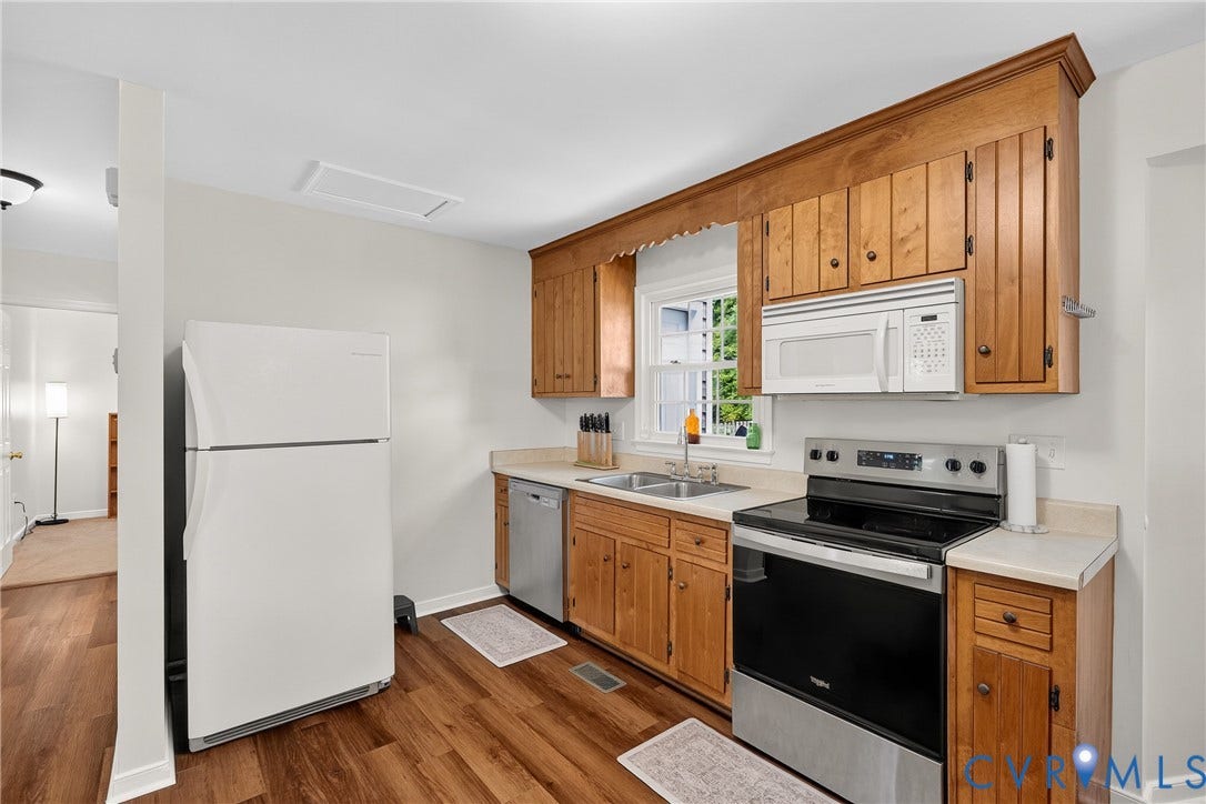 7248 Full Rack Drive, Midlothian, VA 23112 Wood-finish flooring with light wood cabinetry, white countertops, and a double-basin stainless steel sink