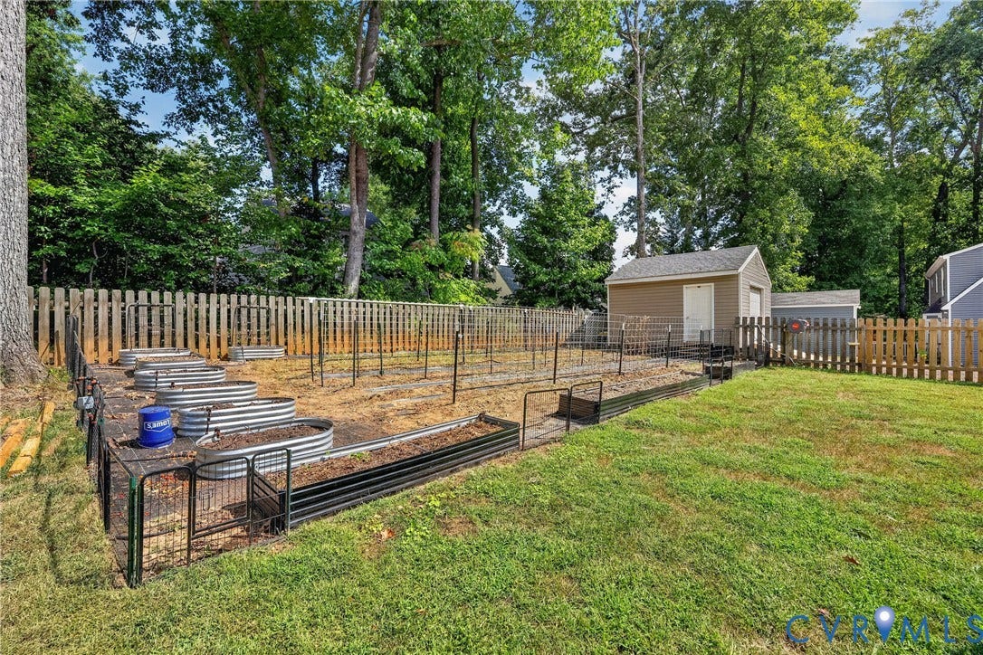 7248 Full Rack Drive, Midlothian, VA 23112 Expansive backyard with a manicured lawn, a garden area featuring raised beds, and a detached storage shed