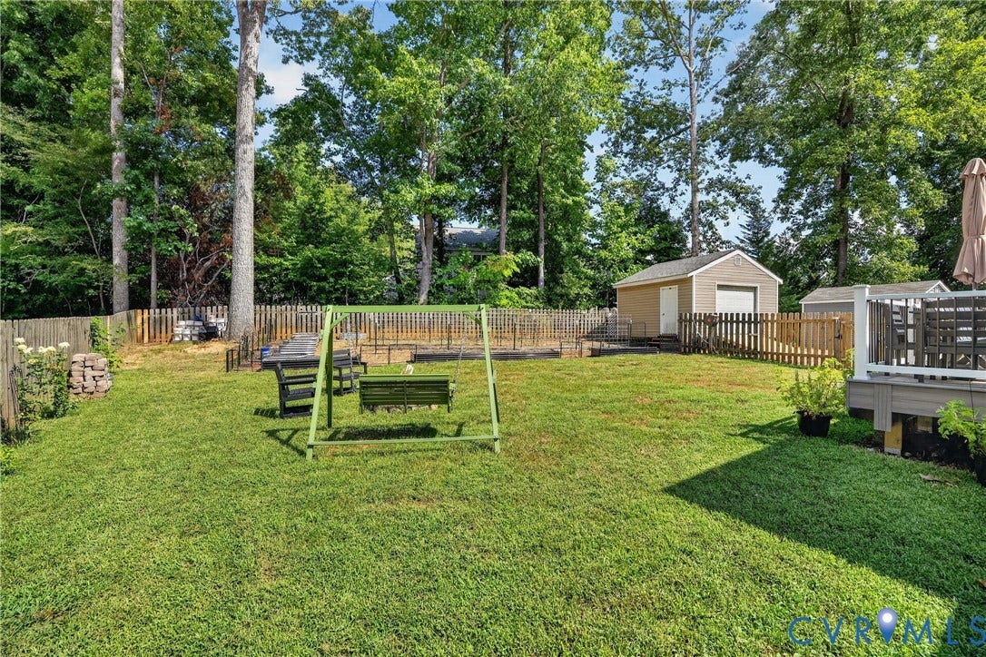 7248 Full Rack Drive, Midlothian, VA 23112 Expansive fenced backyard featuring a detached storage shed, a wood deck, and mature trees