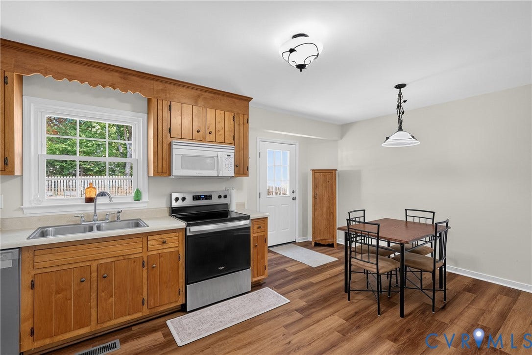 7248 Full Rack Drive, Midlothian, VA 23112 Wood-finish flooring, stainless steel range, stainless steel microwave, double basin sink, and wood cabinetry