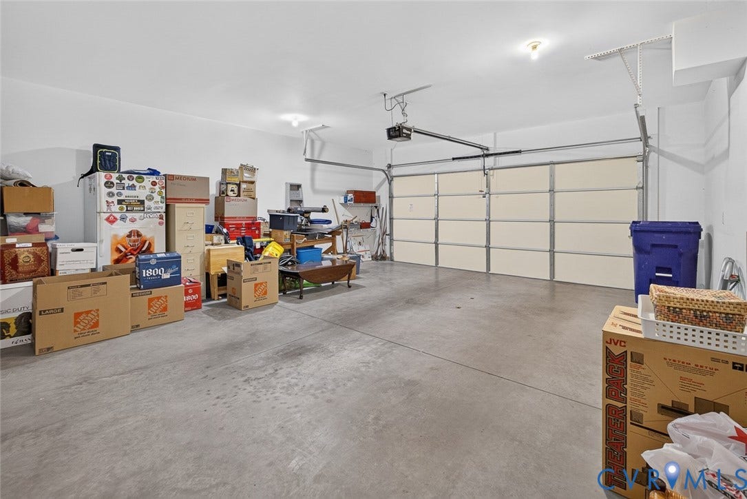 11116 Lantern Way, North Chesterfield, VA 23236 Spacious garage with an overhead door, smooth concrete flooring, and ceiling-mounted lighting