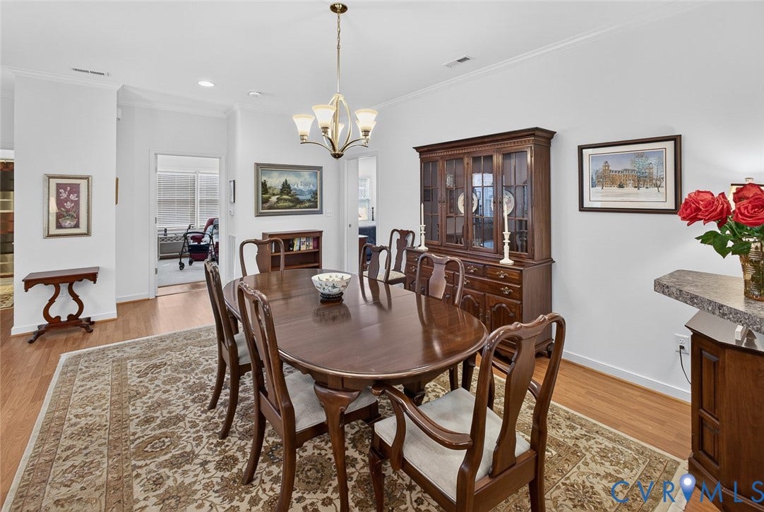 11116 Lantern Way, North Chesterfield, VA 23236 Wood-finish flooring, crown molding, a built-in display cabinet, and a chandelier illuminate this dining area