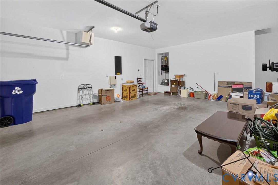 11116 Lantern Way, North Chesterfield, VA 23236 Spacious garage featuring a concrete floor, painted walls, overhead lighting, and an automatic garage door opener
