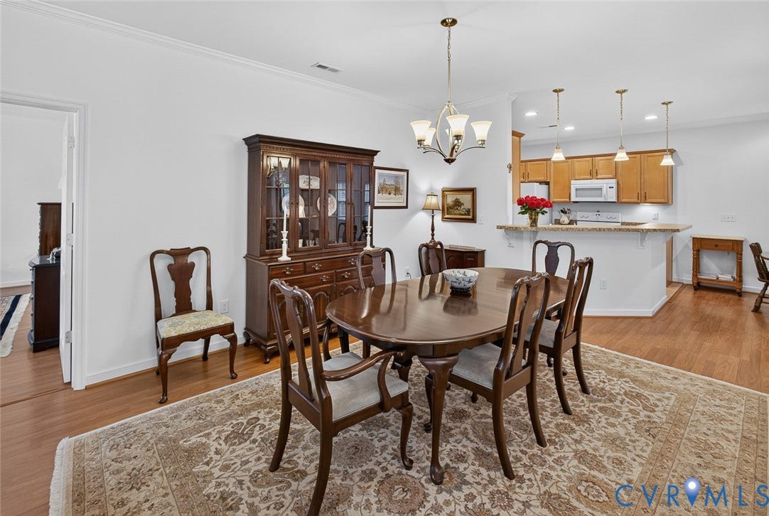 11116 Lantern Way, North Chesterfield, VA 23236 Open-concept dining area featuring wood-finish flooring, a brass chandelier, and crown molding