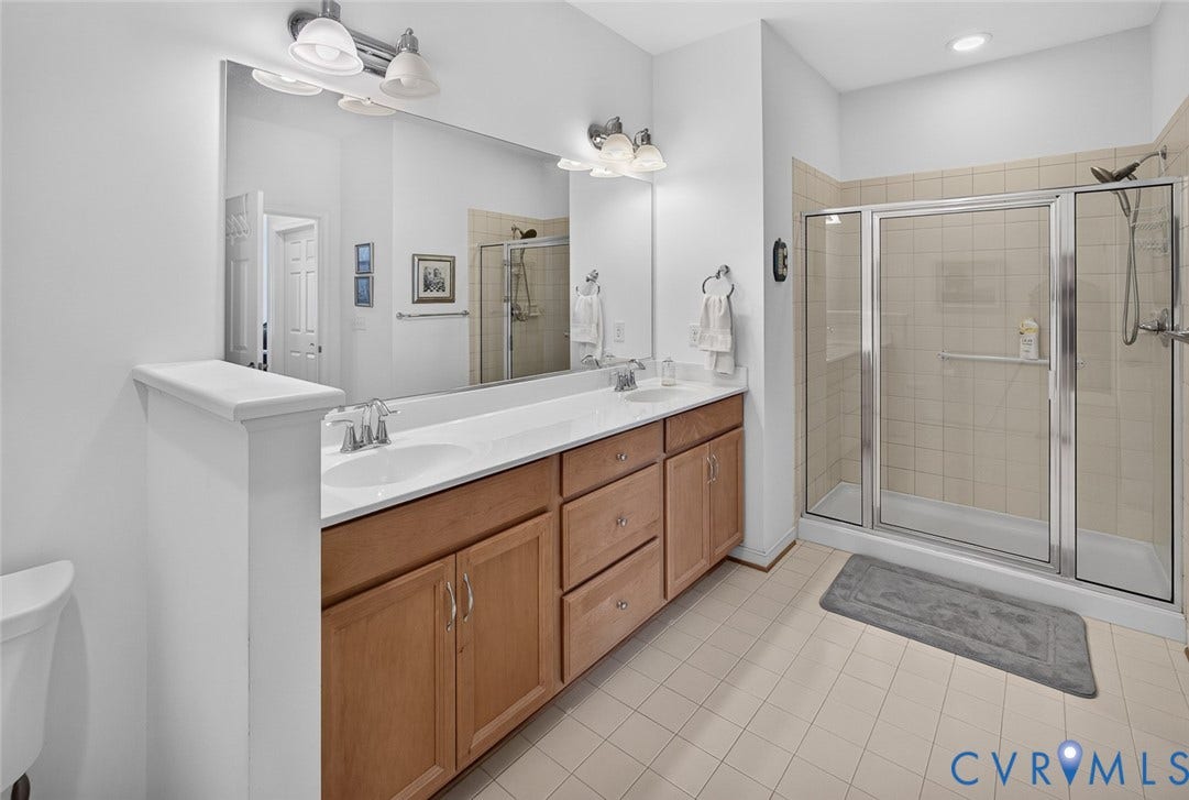 11116 Lantern Way, North Chesterfield, VA 23236 Dual vanity with integrated sinks, wood-finish cabinetry, and a mirrored wall