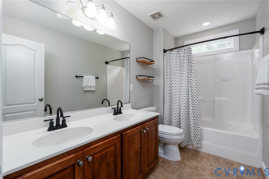 Dual vanity with white countertop and dark wood-finish cabinetry