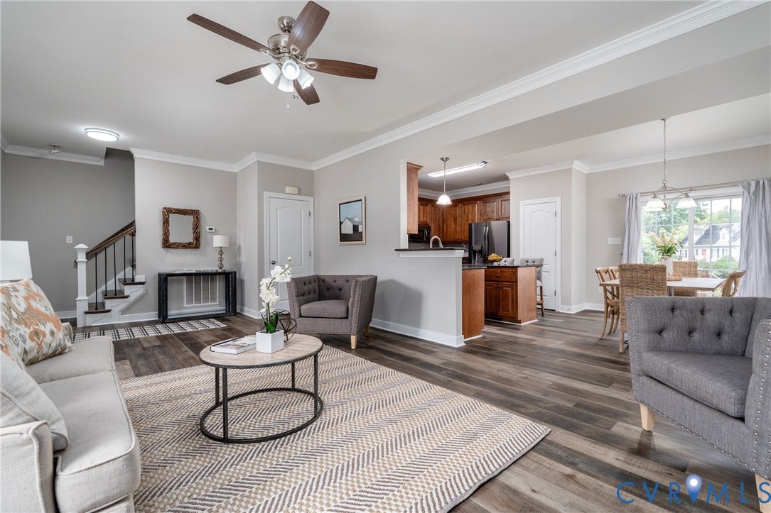 Wood-finish flooring throughout, crown molding, and a modern ceiling fan with integrated lighting