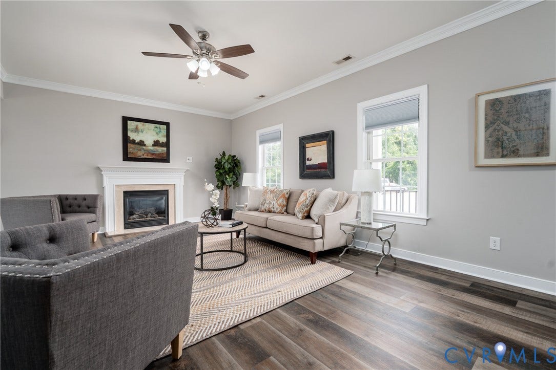 Wood-finish flooring throughout, complemented by a white mantel fireplace