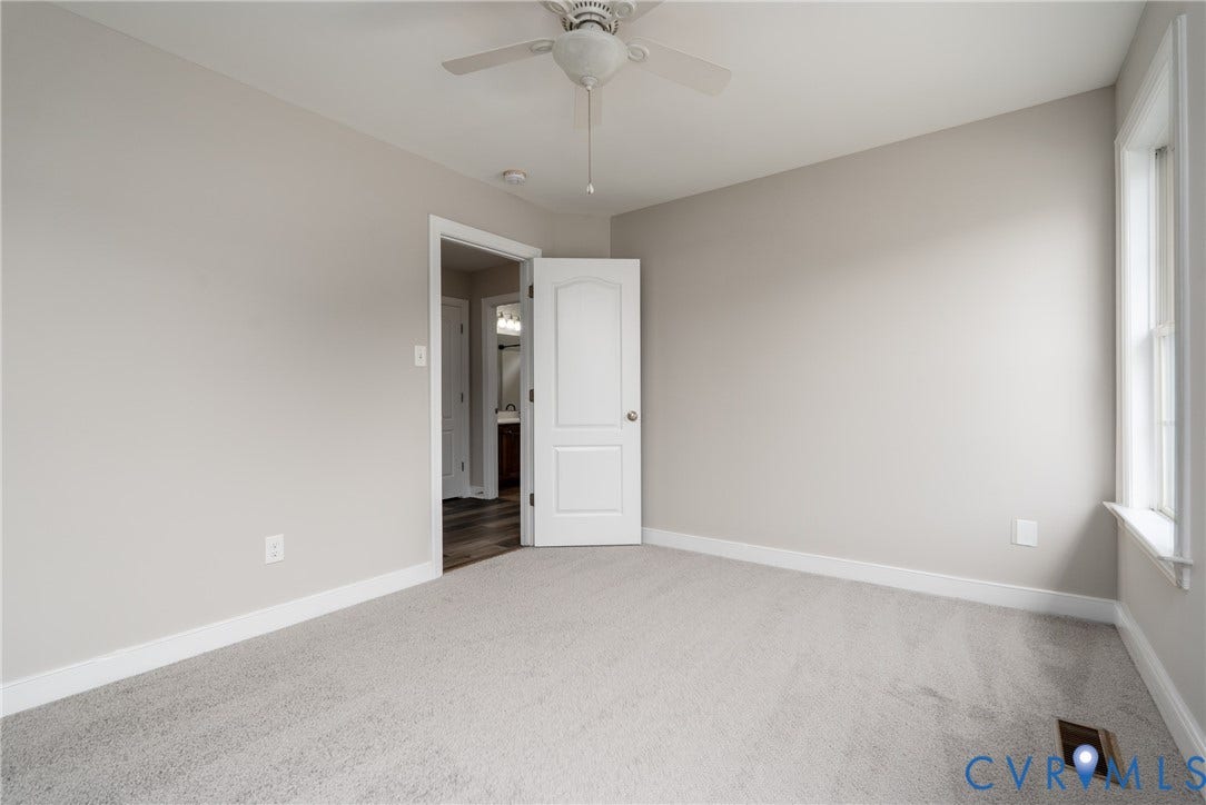 Neutral-toned carpeting, light gray wall paint, and a ceiling fan with integrated lighting
