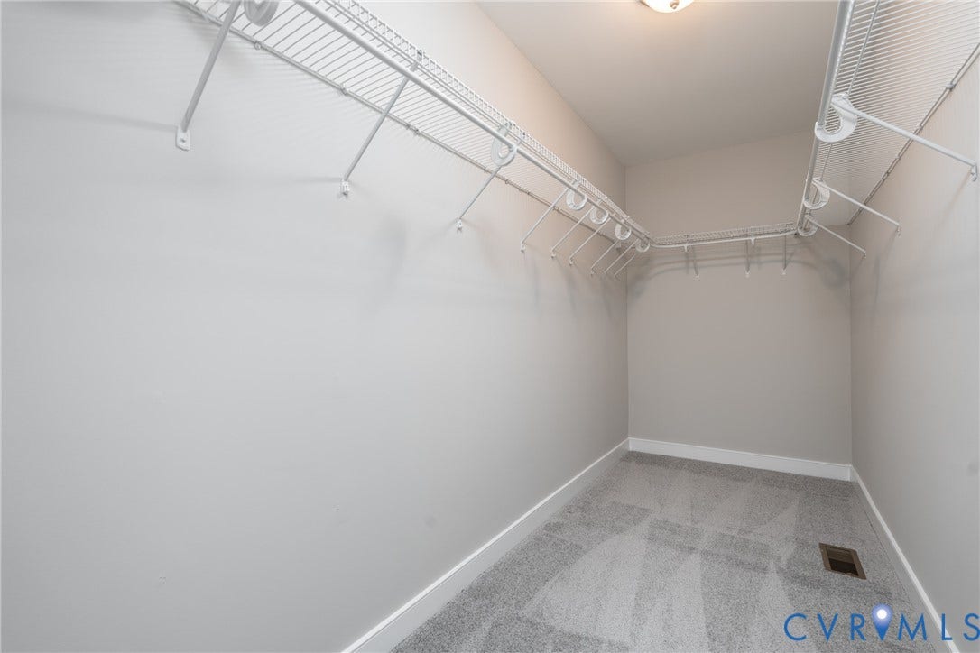 White wire shelving system, light gray wall paint, gray carpet flooring, recessed lighting