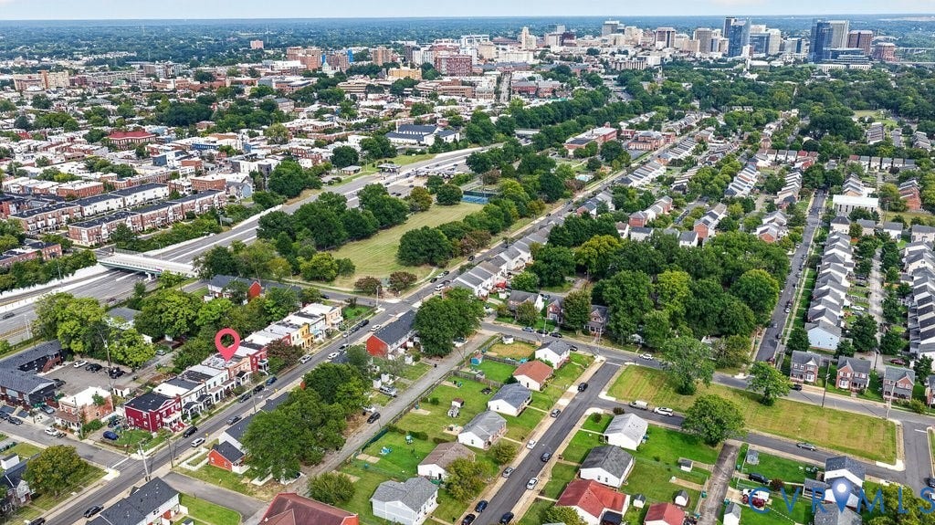1826 Idlewood Avenue, Randolph, Richmond, VA 23220 Aerial overview of a residential neighborhood with mixed architectural styles, mature trees, and a distant cityscape