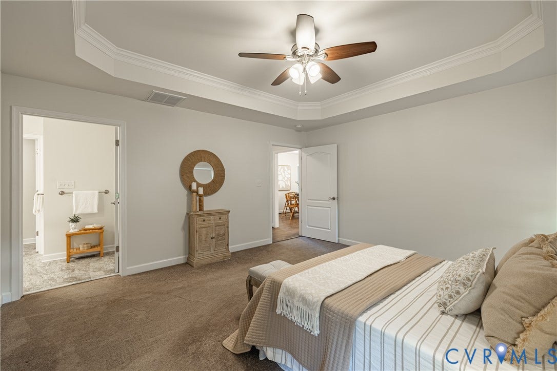 Tray ceiling with crown molding, ceiling fan, carpeted flooring, and white interior doors