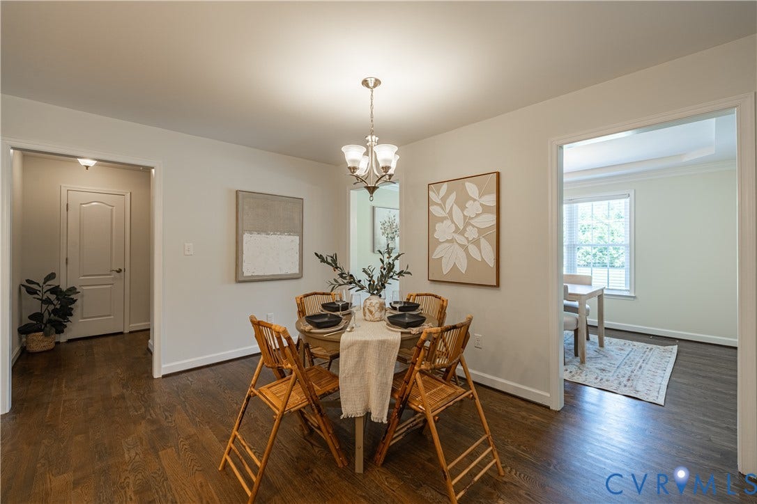 Dining area featuring wood-finish flooring, a contemporary chandelier, and a wide entryway