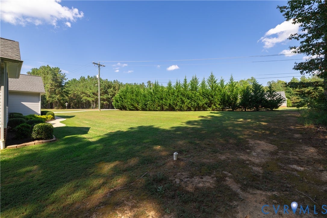 Expansive exterior grounds featuring a manicured lawn, established privacy trees, and mature landscaping