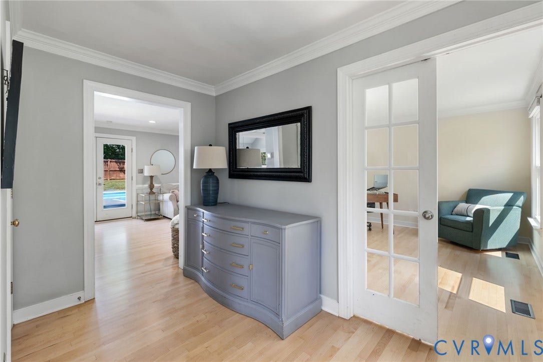 Light wood-finish flooring, crown molding, and a paneled glass French doors that lead to Office