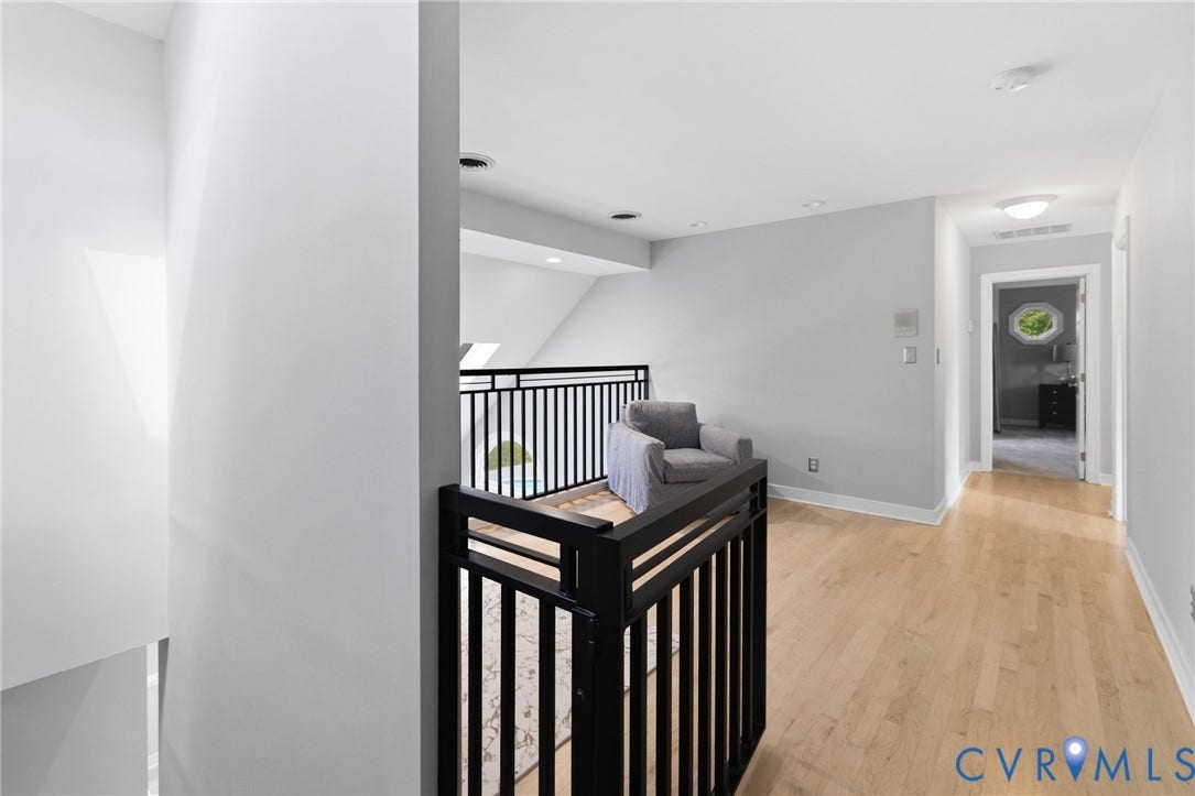 Hardwood flooring, recessed lighting, and a contemporary black metal railing