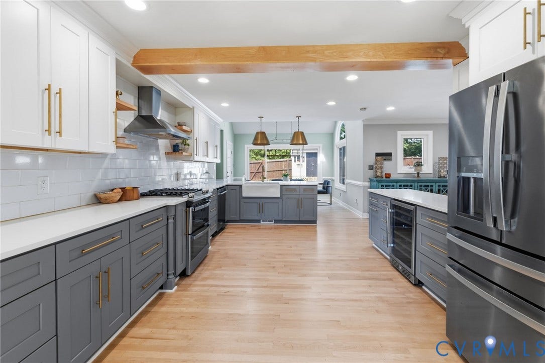 Updated kitchen featuring white shaker upper cabinetry and gray shaker lower cabinetry, stainless steel appliances, light wood-finish flooring, and recessed lighting