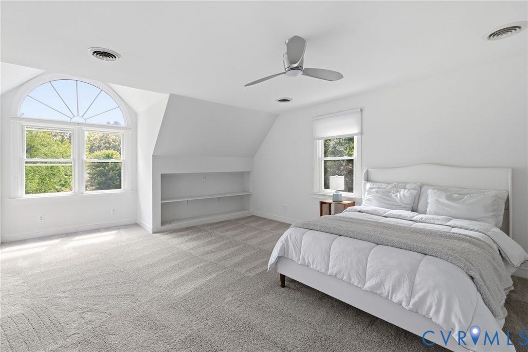 Arched window with upper transom, built-in shelving, sloped ceiling, recessed lighting, and ceiling fan