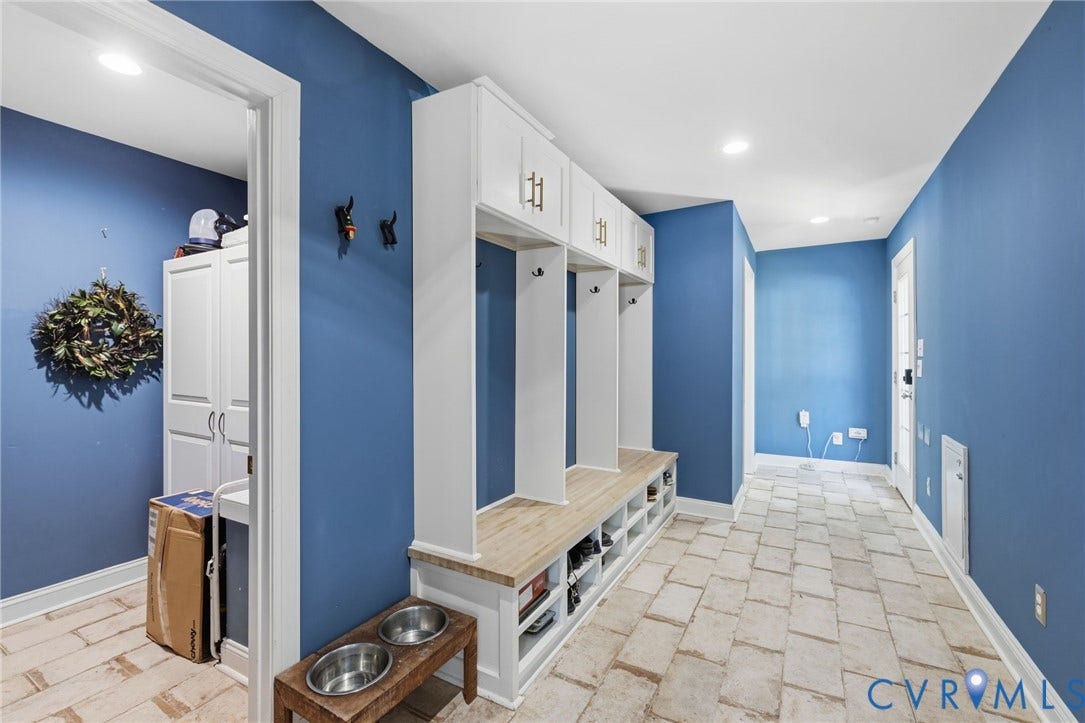 Built-in entryway storage with bench seating, overhead cabinetry, and integrated coat hooks