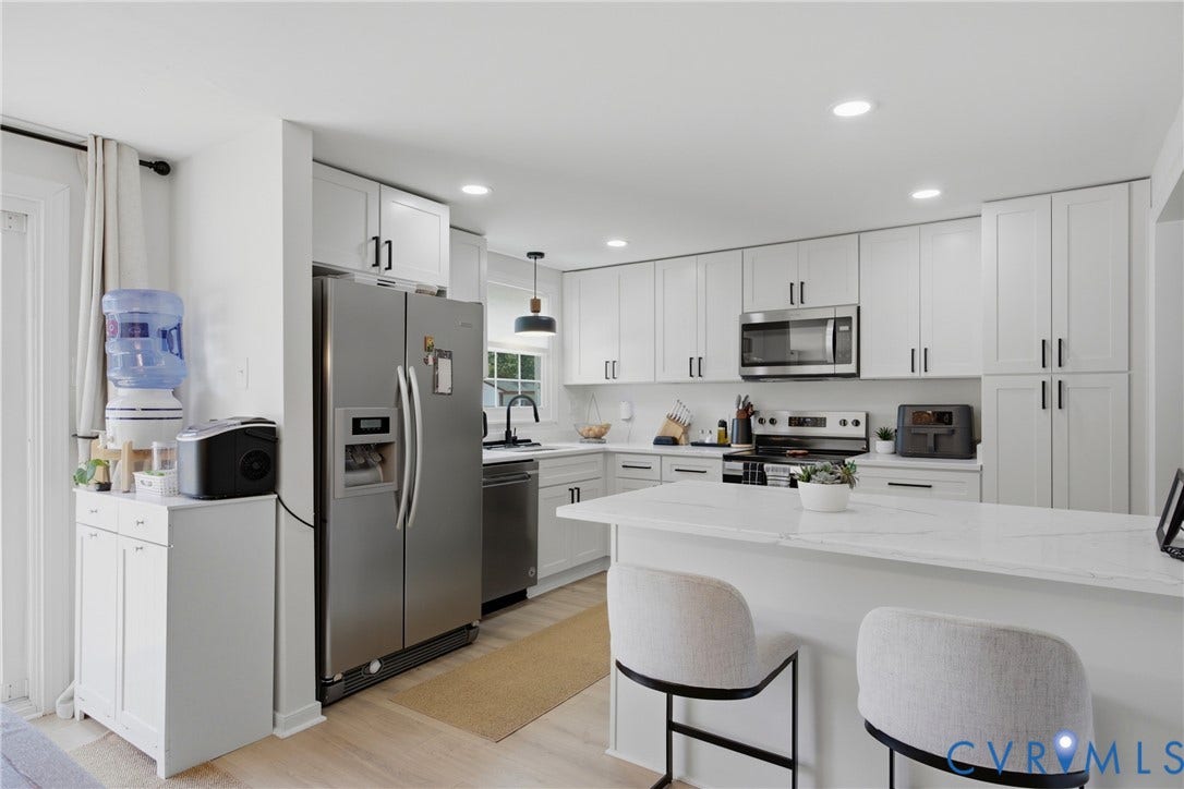 1905 Reagan Road, Henrico, VA 23228 White shaker cabinetry with black hardware, stainless steel appliances, recessed lighting, wood-finish flooring, and a white countertop island