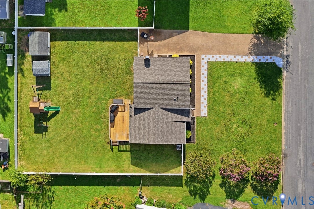 1905 Reagan Road, Henrico, VA 23228 Expansive lot featuring a large deck, two storage sheds, a paved driveway, and a front walkway with square paver stones