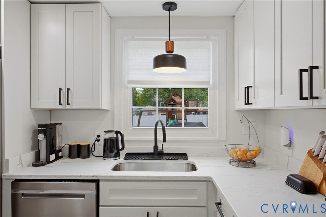 1905 Reagan Road, Henrico, VA 23228 White shaker cabinetry with matte black hardware, stainless steel sink with a gooseneck faucet, light-toned countertops, and a stainless steel dishwasher
