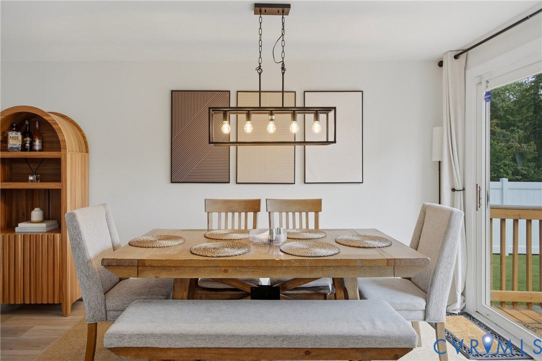 1905 Reagan Road, Henrico, VA 23228 Modern linear chandelier over a wood-finish dining table with upholstered seating