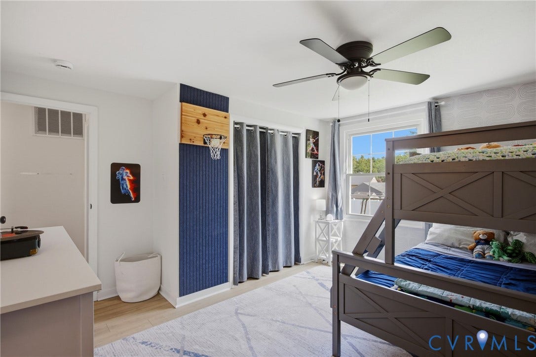 1905 Reagan Road, Henrico, VA 23228 Recessed window with white trim, wood-finish flooring, ceiling fan with integrated lighting, and a built-in wall feature with a textured blue panel