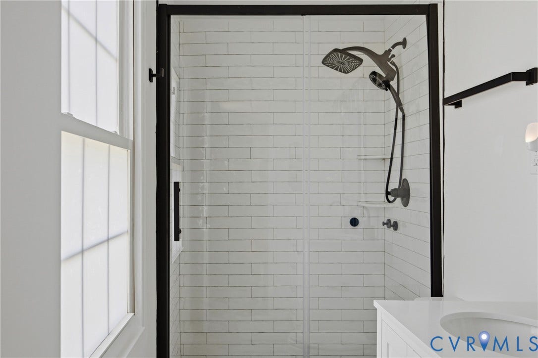 1905 Reagan Road, Henrico, VA 23228 Shower enclosure with black framing, white subway tile surround, and a matte black shower system