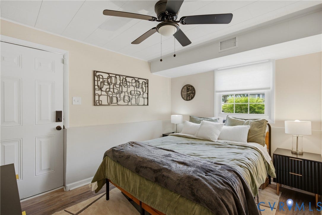 1905 Reagan Road, Henrico, VA 23228 Wood-finish flooring, white paneled door, ceiling fan with integrated lighting, window with roller shade, and built-in wall trim