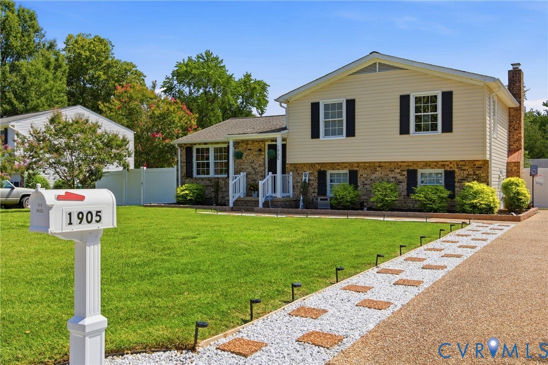 1905 Reagan Road, Henrico, VA 23228 Split-level residence featuring a brick and siding exterior, front porch with white railing, and a gravel driveway