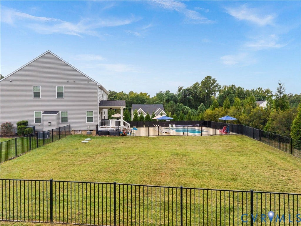 11707 Amara Drive, Chester / Highlands Golf Club, Chesterfield, VA 23838 Expansive backyard featuring a fenced-in swimming pool, a covered deck, and a gray siding exterior