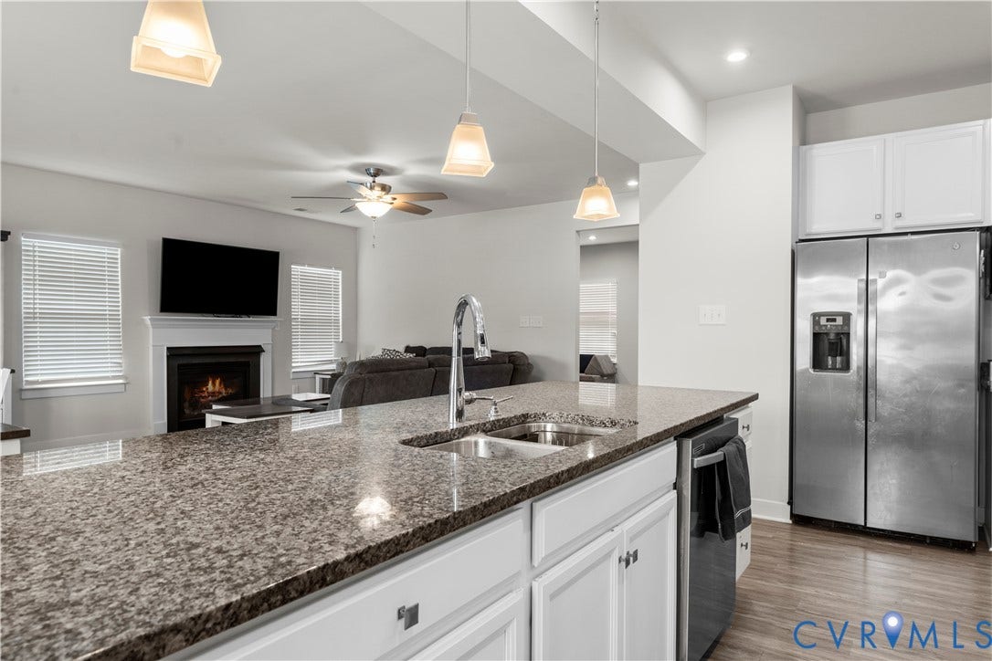 11707 Amara Drive, Chester / Highlands Golf Club, Chesterfield, VA 23838 Kitchen island with stone-finish countertop, stainless steel sink with a high-arc faucet, white cabinetry, and recessed lighting