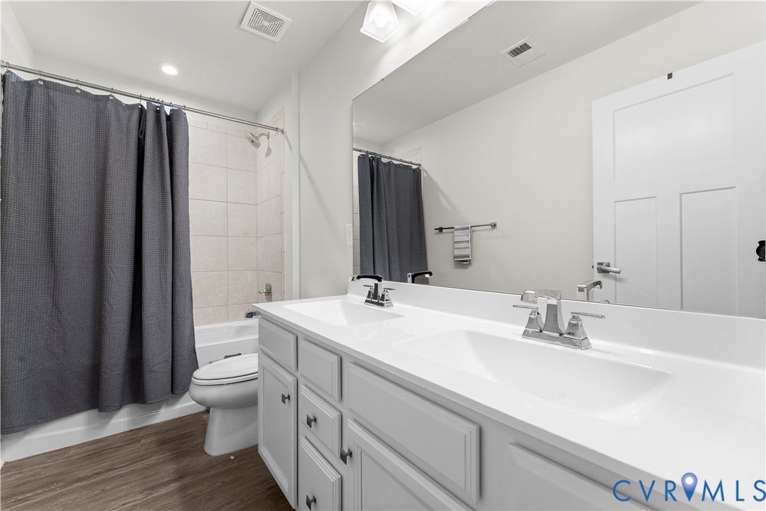 11707 Amara Drive, Chester / Highlands Golf Club, Chesterfield, VA 23838 Dual vanity with integrated sinks, wood-finish flooring, white cabinetry, and a full-width mirror