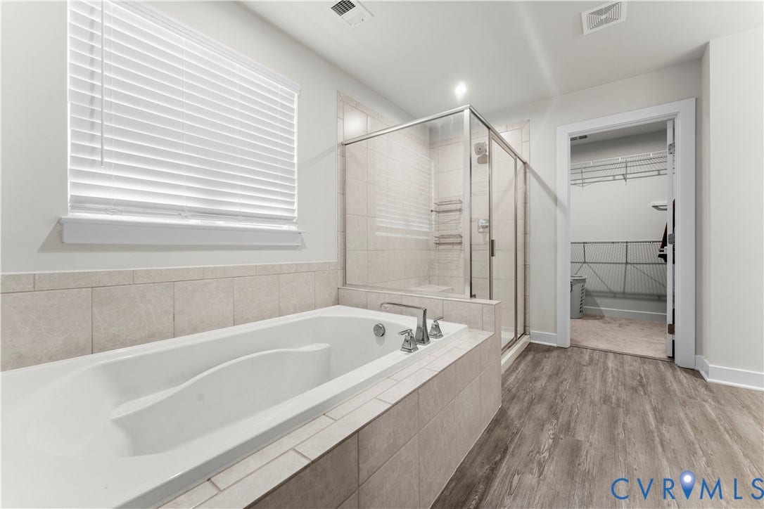 11707 Amara Drive, Chester / Highlands Golf Club, Chesterfield, VA 23838 Soaking tub with tile surround, glass-enclosed shower, wood-finish flooring, and a window with blinds