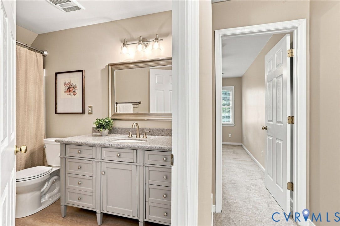 Bathroom featuring a vanity with a light-colored countertop, an undermount sink, and a brushed nickel faucet