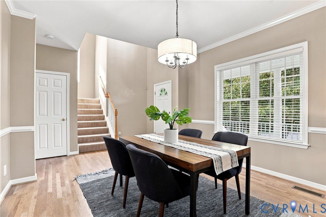 Hardwood-finish flooring, crown molding, chair rail detailing, a five-panel interior door, and a drum-shade chandelier