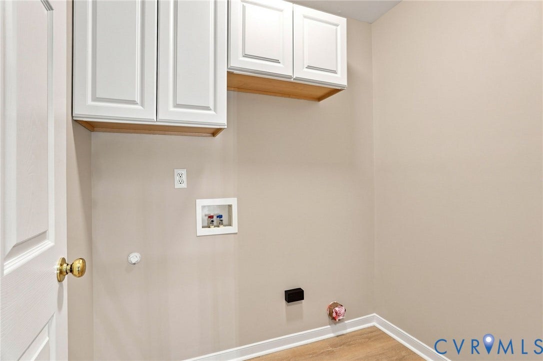 White shaker-style cabinetry with warm wood-finish flooring