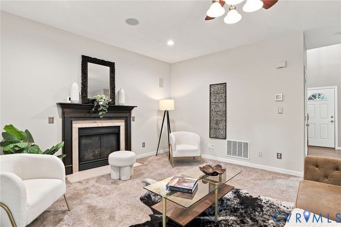 Living area featuring a dark wood mantel fireplace with stone surround, recessed lighting, and carpet flooring