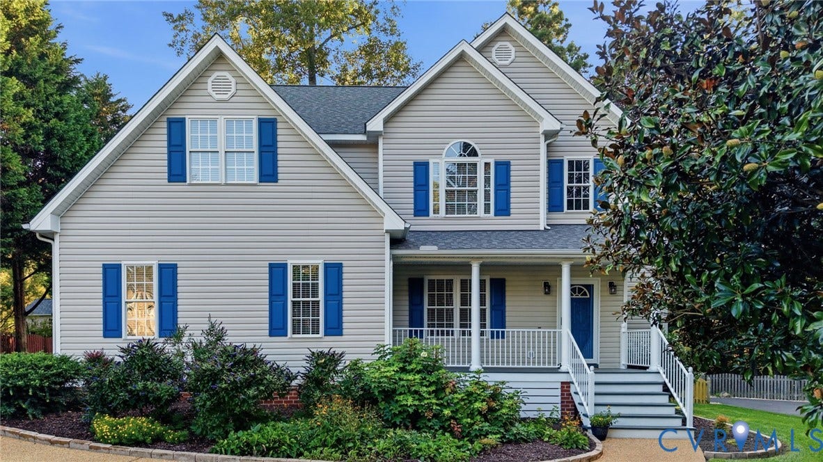 Two-story residence featuring light-colored siding, a covered front porch, and a gable roof