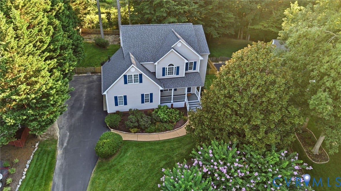 Gable roofline, light gray siding, dark blue shutters, covered front porch, and asphalt driveway